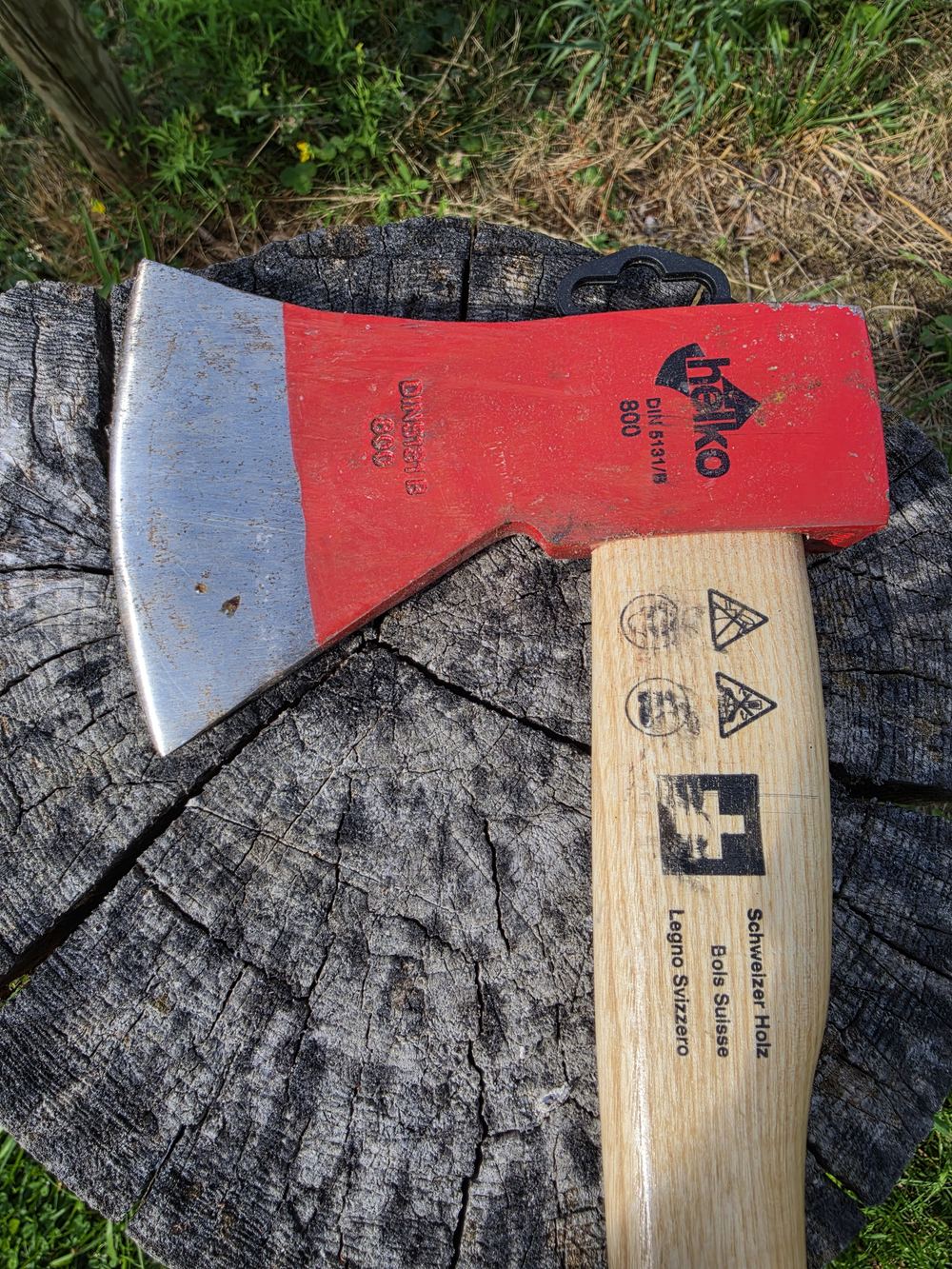 Beil mit Schweizer Holzstiel auf einem Holzstrunk