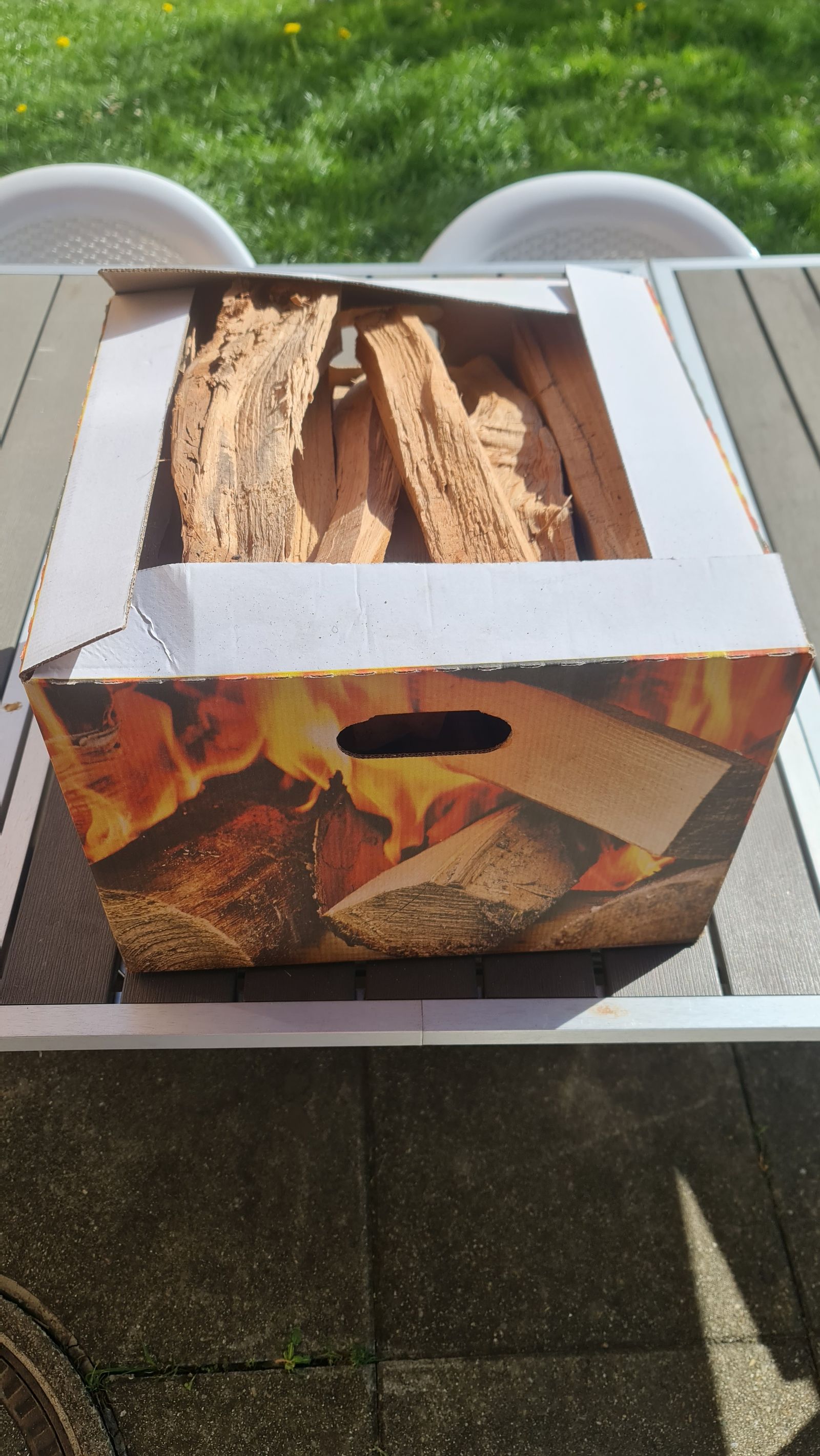 Karton mit trockenem, ofenfertigem Brennholz