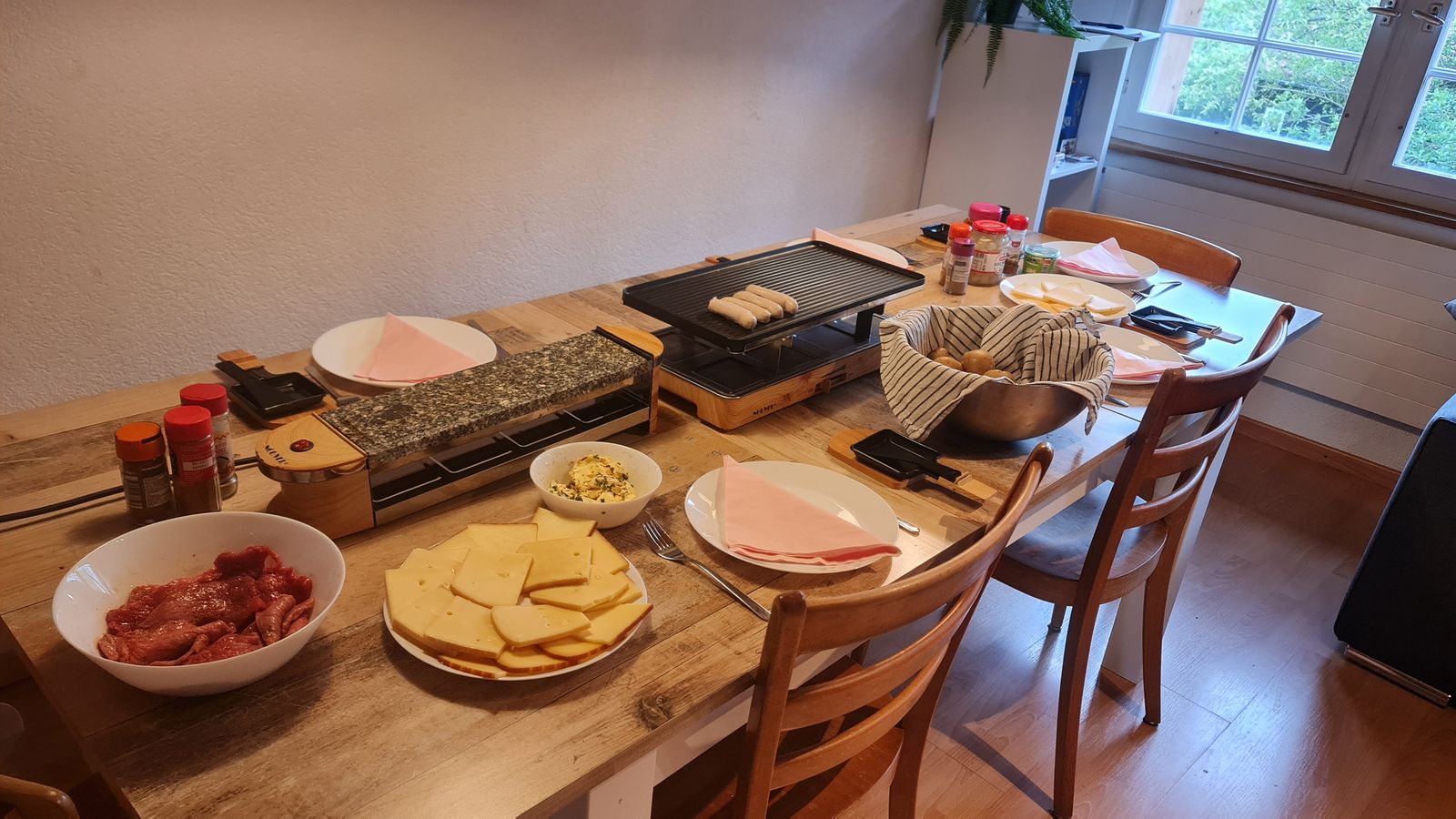 Gedeckter Tisch mit Raclette-Öfen und heissem Stein im Landhaus
